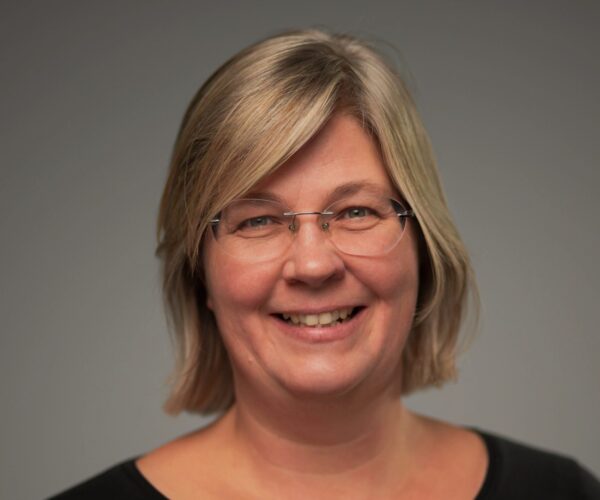 Portret van een lachende blonde vrouw met bril